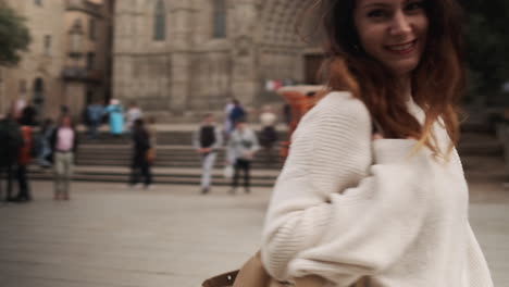 smiling woman with beige bag in the middle of old big square