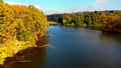 autumnal forest lake scenery with people