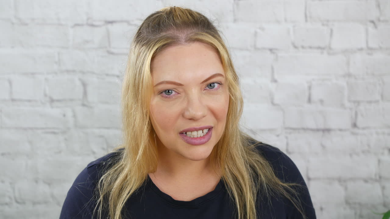 una mujer rubia gruñendo enojada rechinando dientes