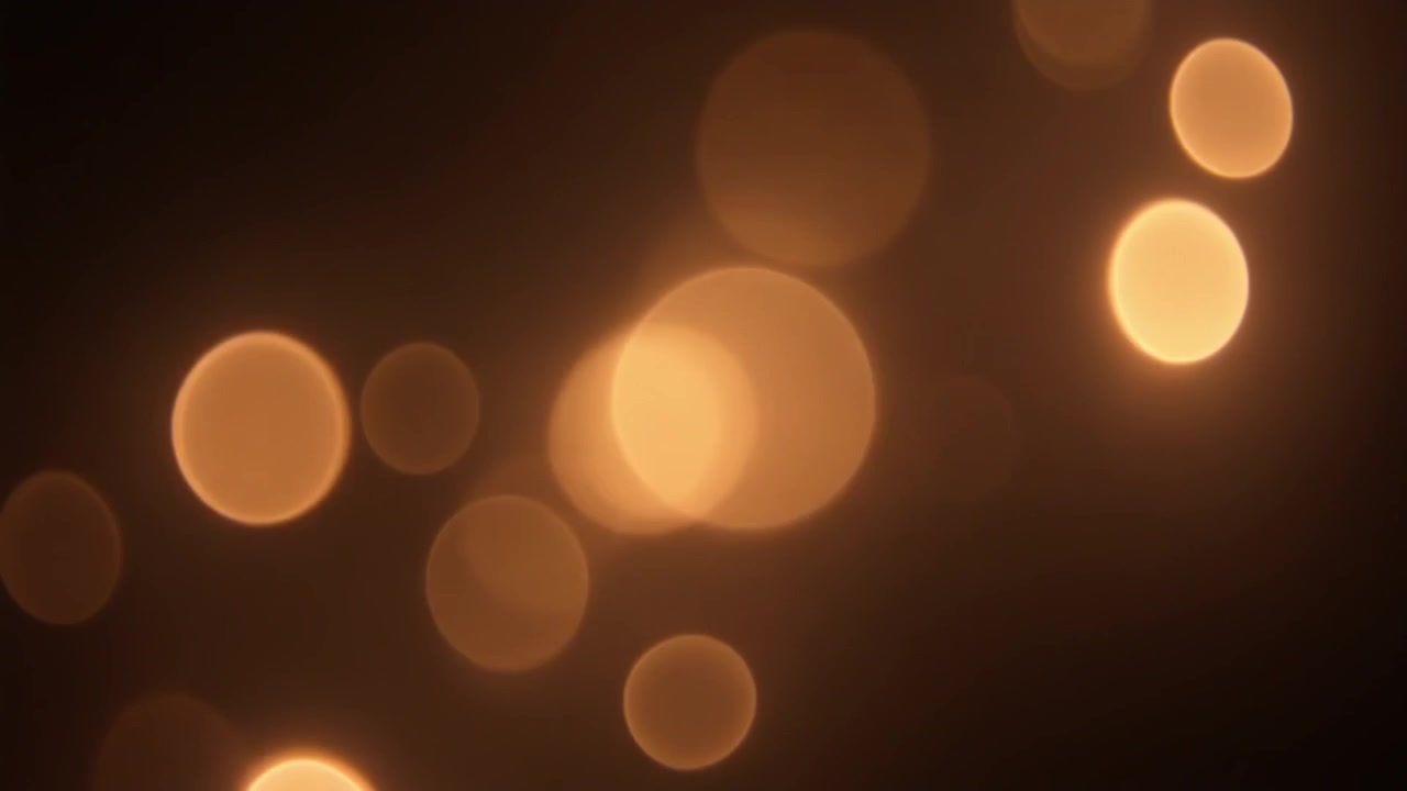 Luci bokeh dorate astratte che fluttuano su sfondo scuro