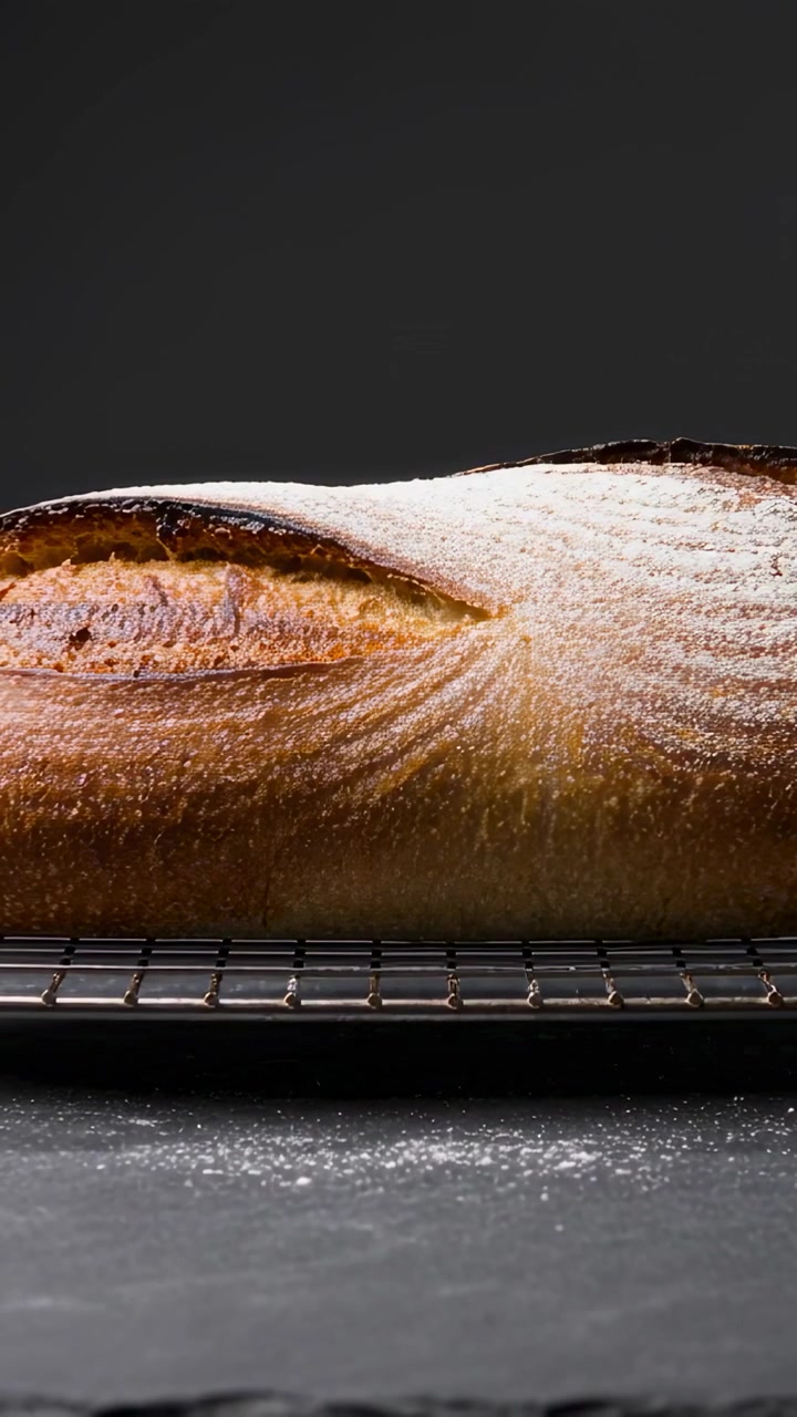 Vertical video: Oven stopping letting hot baguette cooling on metal rack studio flour dusting