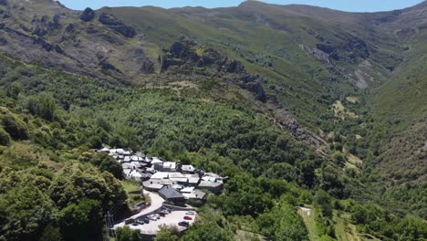 volando hacia atrás revelando las montañas que rodean un pequeño pueblo de piedra