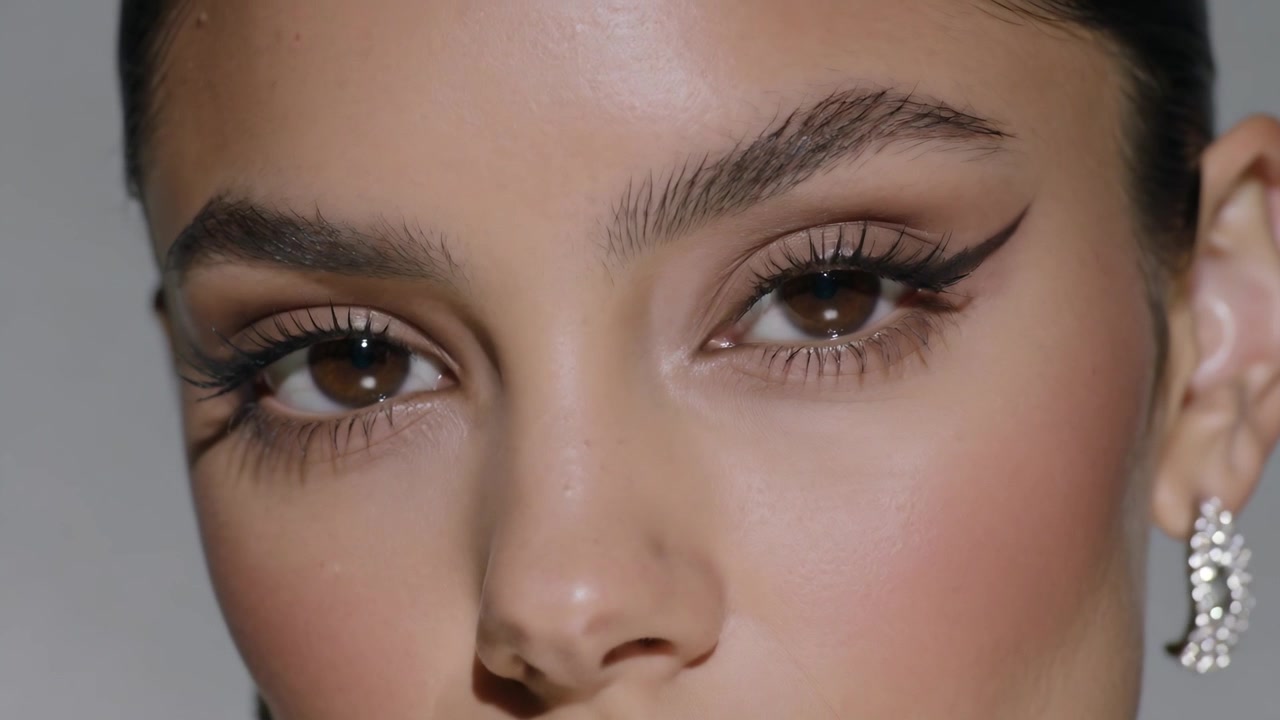 Camera tightening framing, model shifting gaze, turning head right in studio, highlighting earrings