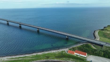 great belt bridge crossing strait between funen and zealand in denmark - stunning aerial following cars at bridge entrance before revealing full panoramic view of bridge