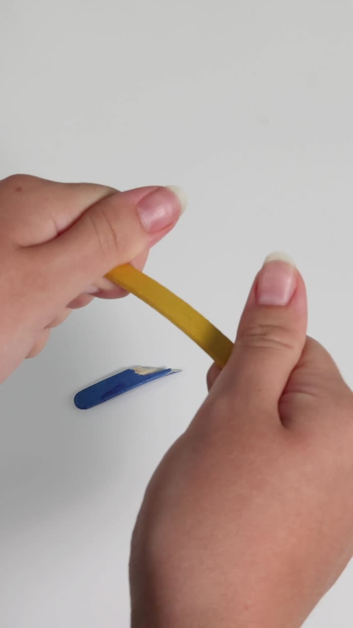 dos manos rompiendo un lápiz en dos pedazos