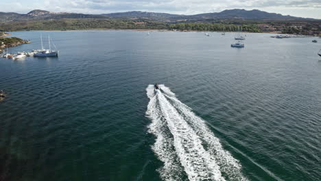 Speedboat-cutting-through-calm-blue-waters-in-Sardinia-on-a-sunny-day