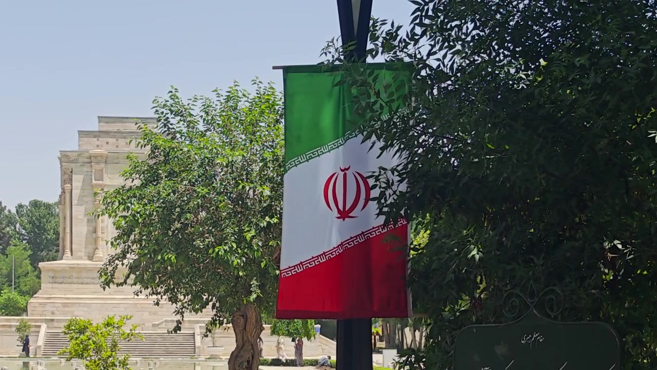 Flag of Iran Hanging on a Pole in a Park