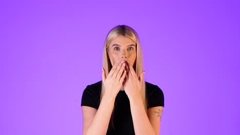 young blonde woman astonished, pointing her index finger, colorful studio portrait