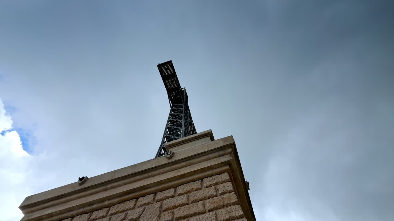Close view of Caraiman Cross monument in Bucegi Mountains. Low angle view of the iconic Caraiman Cross structure under cloudy sky