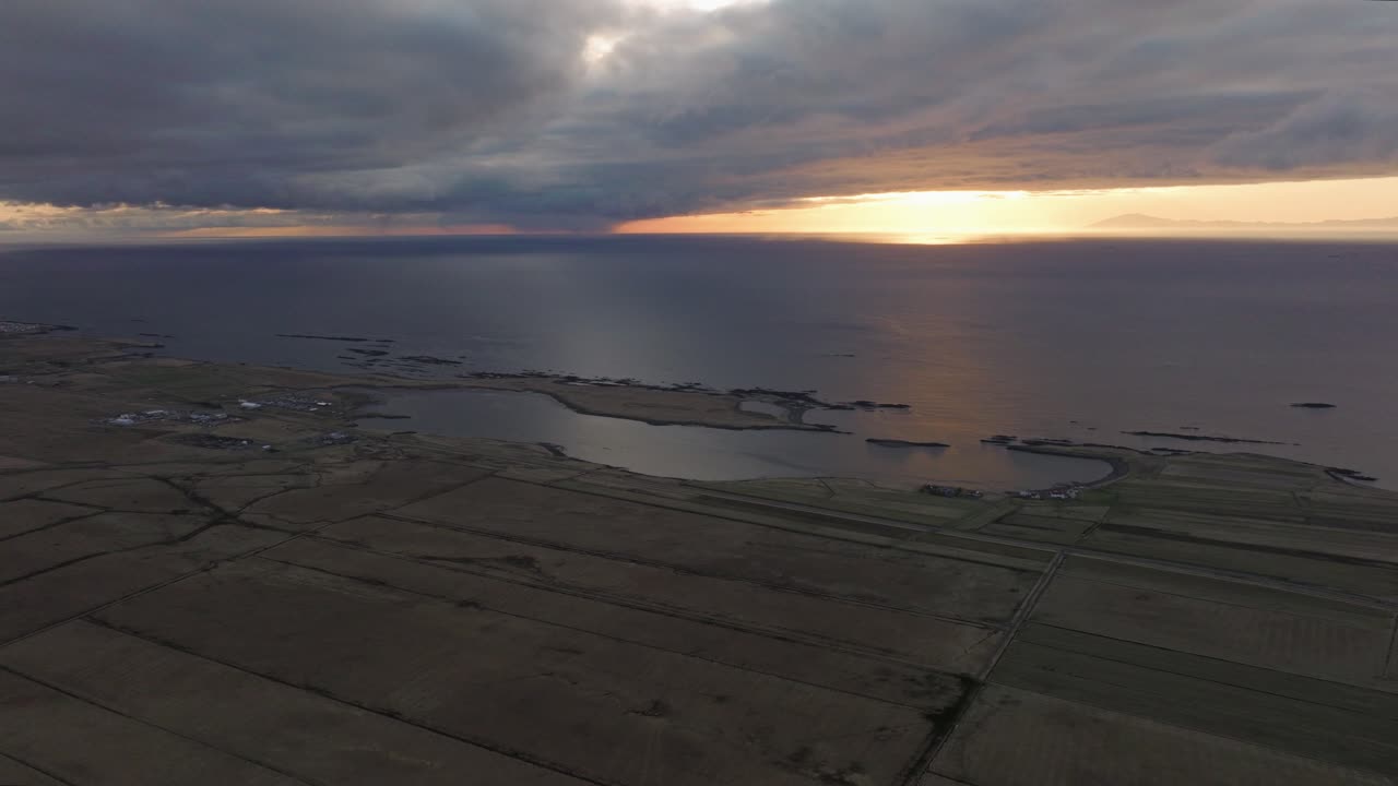 아이슬란드 아크라네스 근처의 해안 농지 위에서 해가 지는 공중 풍경, 극적인 구름과 해가 바다에 반사되는 모습