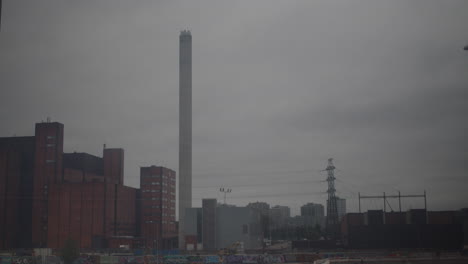 Tiro-De-Lapso-De-Tiempo-De-Nubes-Grises-Que-Pasan-Sobre-La-Planta-De-Energía-De-Suvilahti