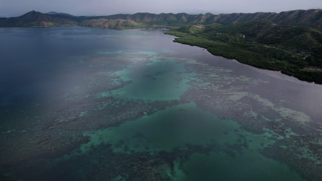 panorámica aérea panorámica de la costa en filipinas con aguas turquesas y exuberantes montañas costeras