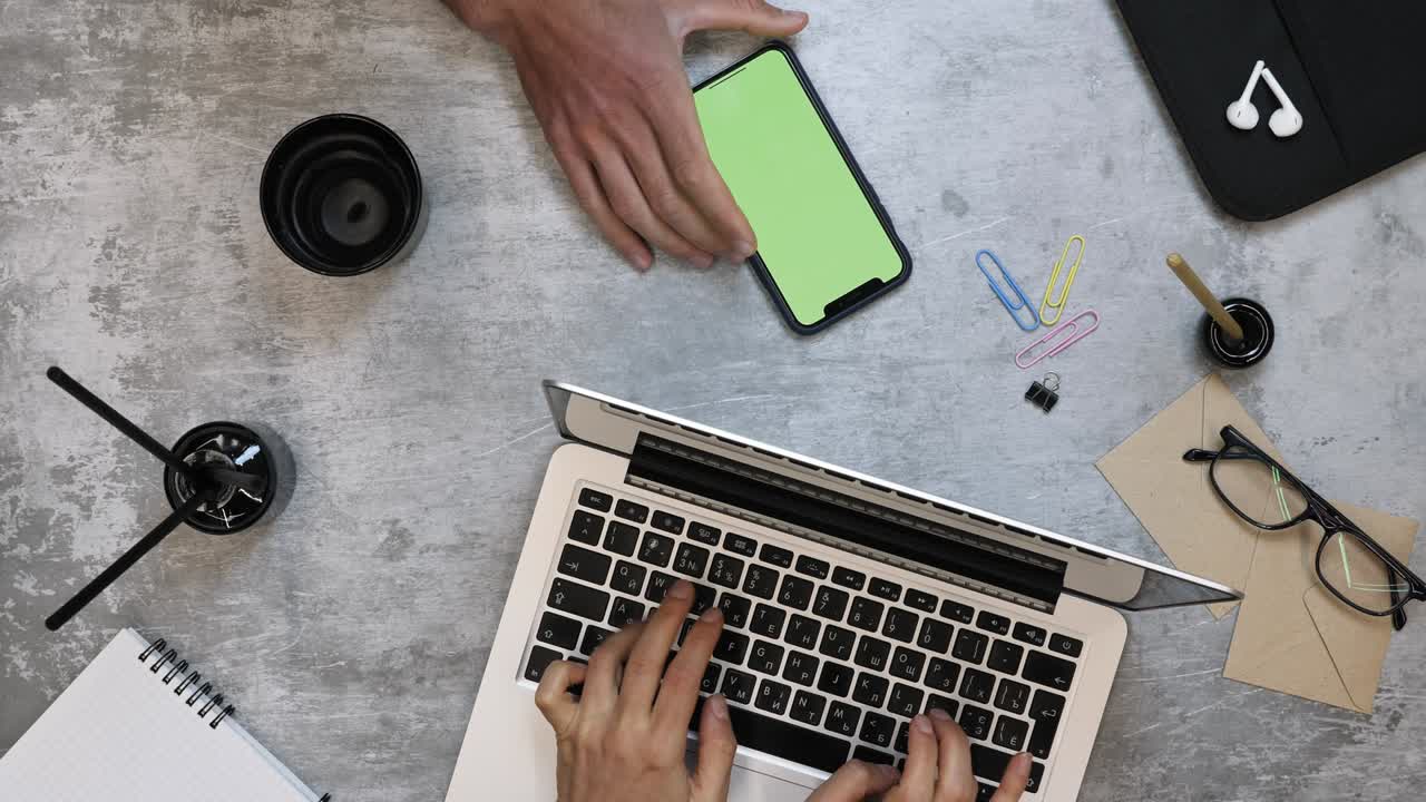 Business people working on laptop computer and smartphone with chroma key green screen at work desk in modern office.  Group of people on meeting in big busy corporate office. Coworkers in office