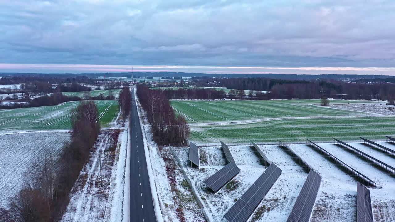 시골과 함께 도로를 따라 눈 인 라트비아의 공중 풍경 재생 가능한 태양광 농장 수집기 배열