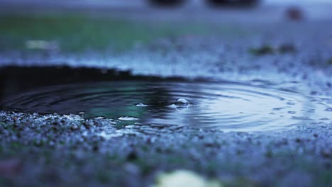 Drei-Große-Wassertropfen,-Die-In-Einer-Pfütze-Auf-Den-Beton-Fallen