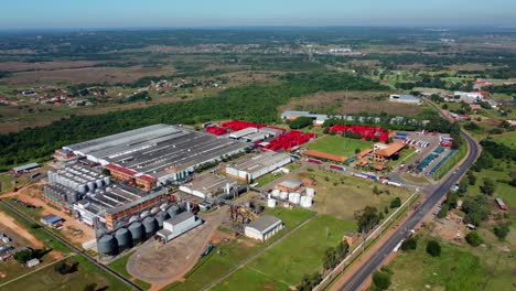 Aerial-view-of-industrial-buildings-at-the-suburb-of-the-city,-next-to-forest-and-nature