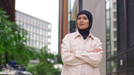 Portrait-Of-Smiling-Muslim-Businesswoman-Wearing-Hijab-With-Business-Suit-Going-To-Work-Standing-Outside-Modern-Office-Buildings-3