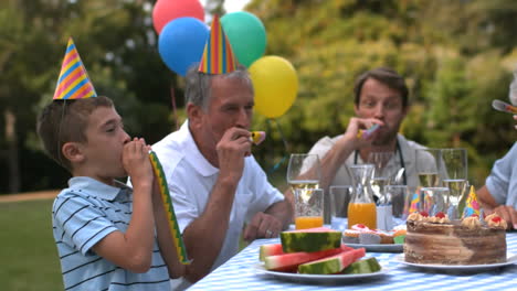 animation of paper burning over happy family at birthday party