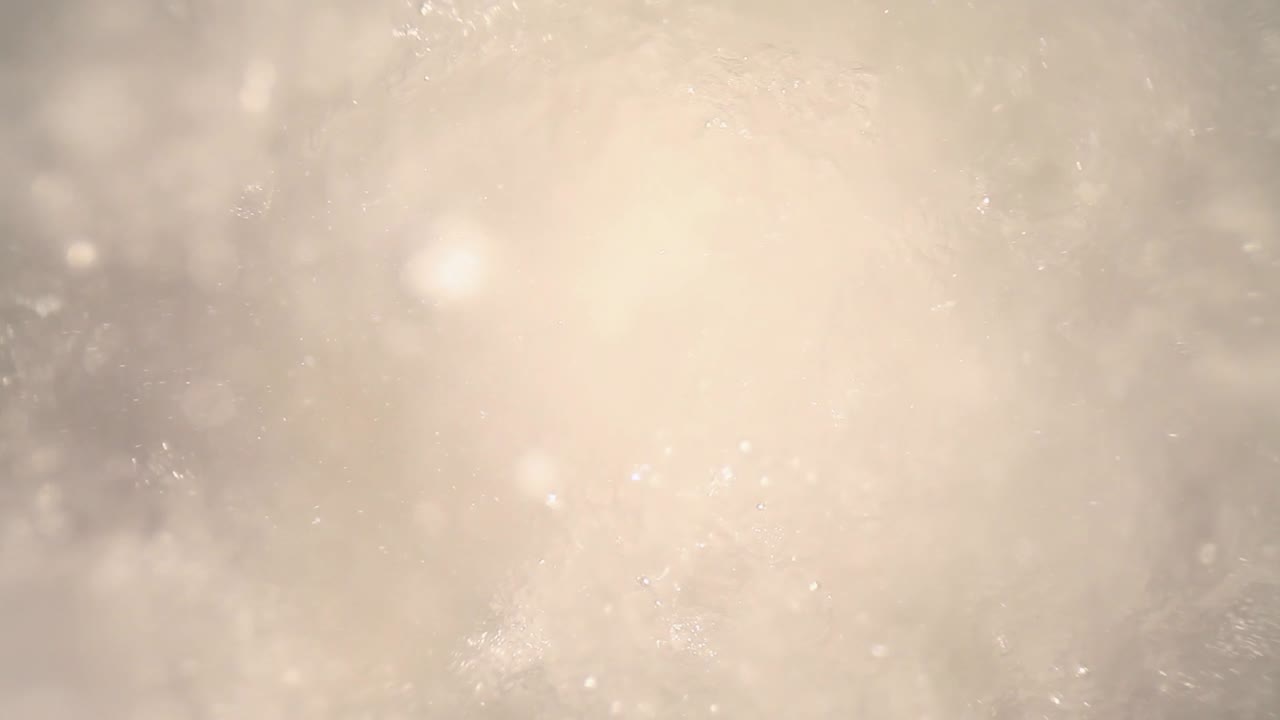 sumergido en una licuadora llena de cubitos de hielo picado - agua, empujando hacia el hielo mientras las partículas en el agua flotan alrededor