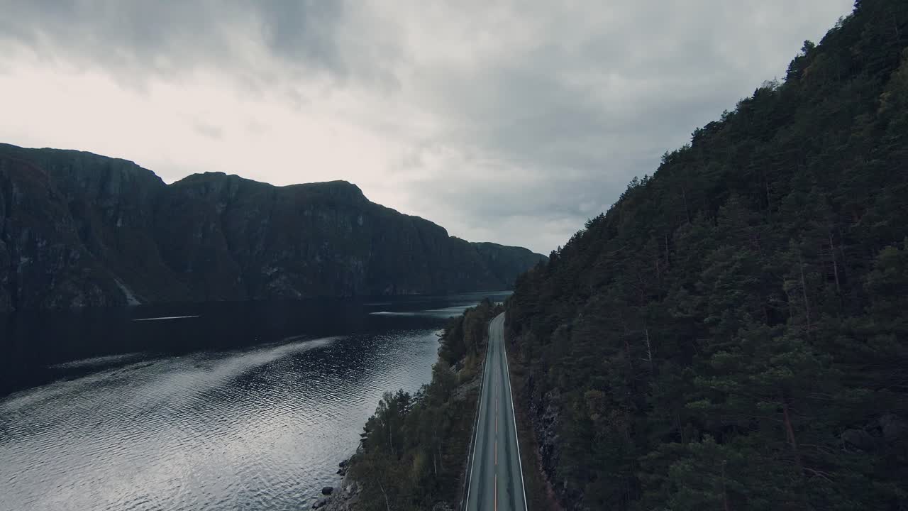 paisaje montañoso con agua de lago y carretera asfaltada, vista aérea de drones