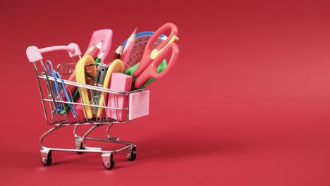 Close-up-of-shopping-trolley-with-school-items-with-copy-space-on-red-background