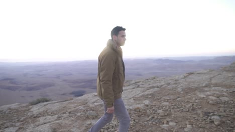 Man-walking-in-the-desert-with-beautiful-early-morning-background