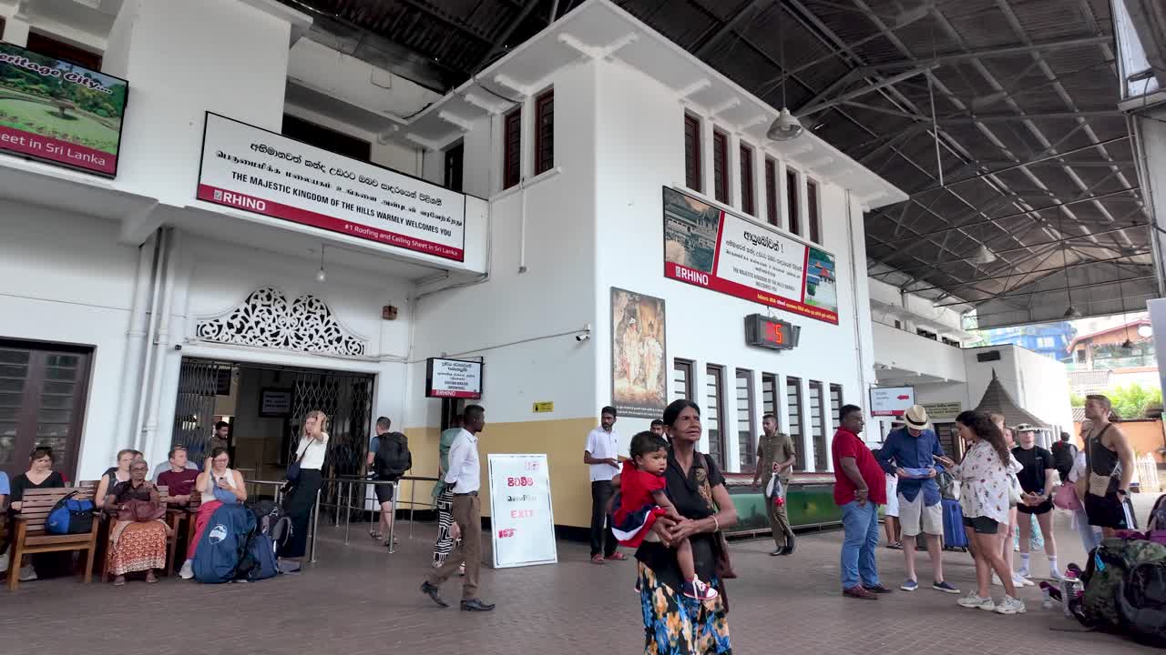 Kandy train station featuring a mix of travelers and locals engaging with their surroundings, capturing the essence of Sri Lankan culture and transport.