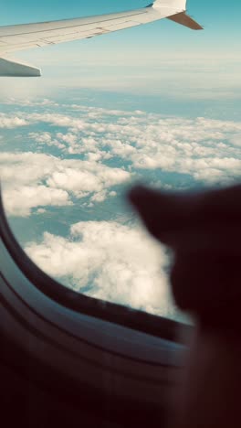 vista de las nubes y el paisaje por la ventana del avión
