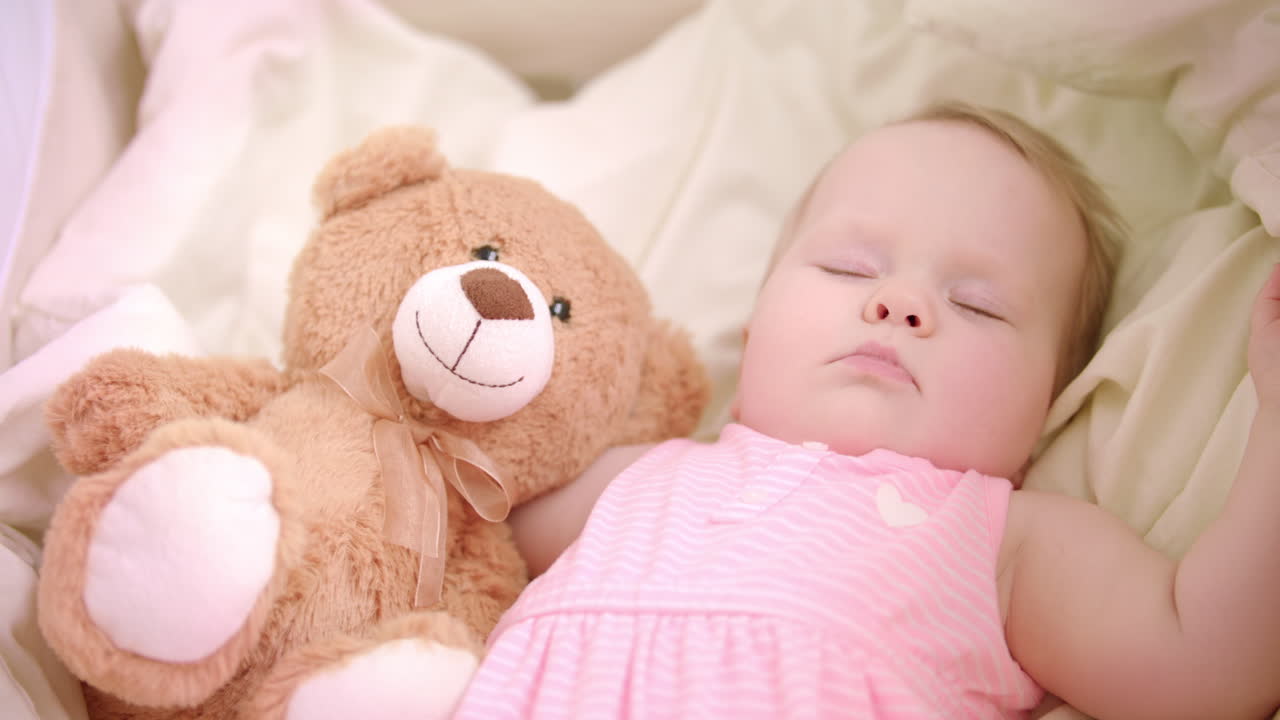 Bimba che dorme con un giocattolo nella culla. Dolce ora della nanna. Sogni della bambina nel letto