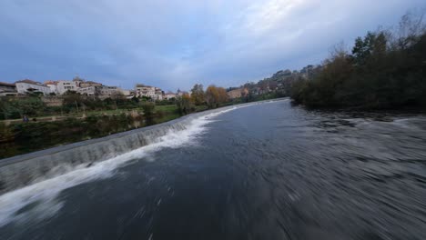 drone fpv de ángulo bajo de alta velocidad que vuela sobre el río tamega, amarante