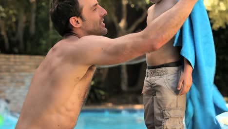 padre secando a su hijo con una toalla