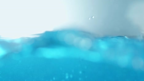 The-clean-water-surface-in-slow-motion-fills-the-screen-with-water-splashing-shop-the-water-drop-and-waving-liquid-surface-with-an-air-bubble