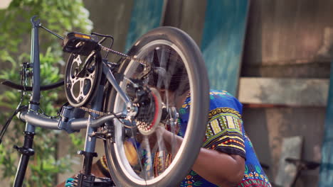 Woman-fixing-bicycle-wheel-outside