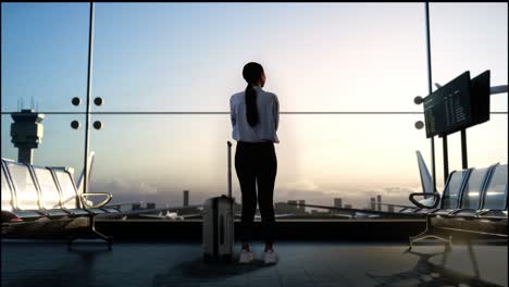 full body back view of asian woman with rolling suitcase in boarding lounge at the airport, crossing her arms and looking around while waiting for flight, airplane takes off outside the window