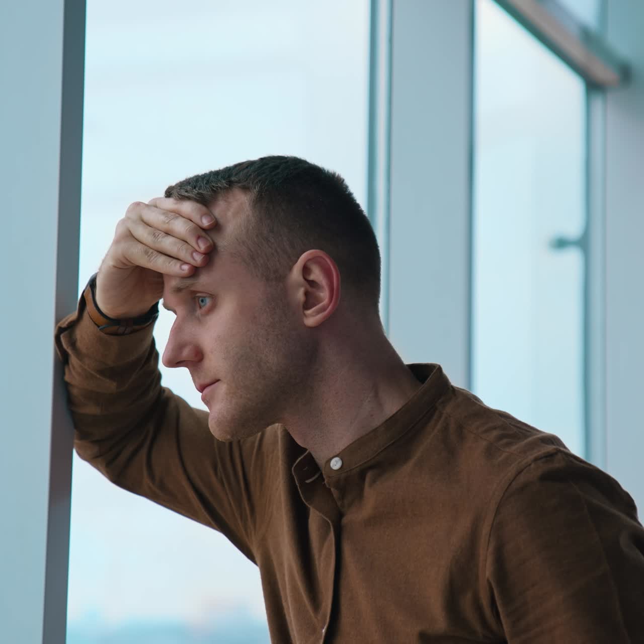 Young businessman looking through the window