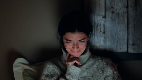 the right decision: young woman smiling and nodding at laptop content, relaxed at home