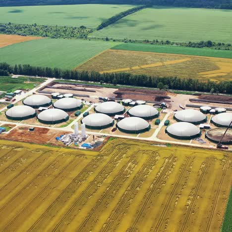 storage tanks for biomass on fields background. agricultural and greenhouse complex is equipped with its own biogas. aerial view