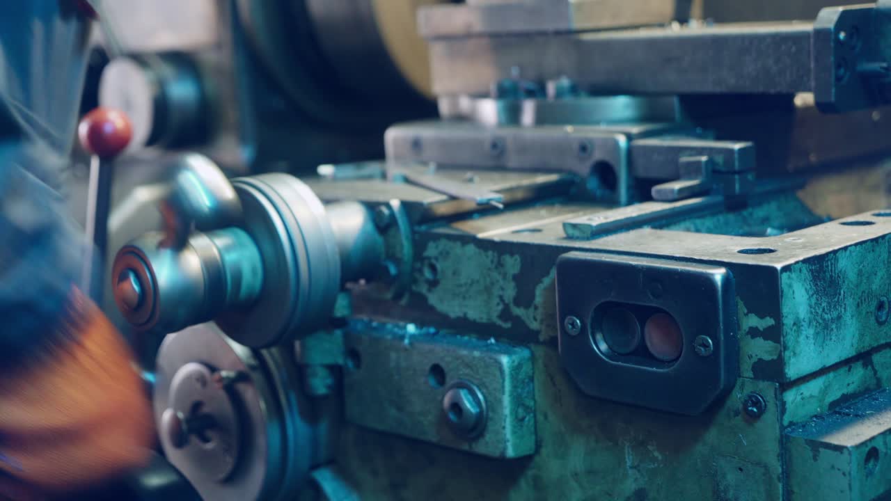 Young mechanic working on a lathe. Metalworking industry.