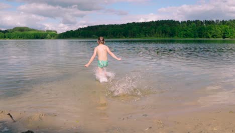 Un-Niño-Lindo-Con-Gafas-De-Natación-Corre-Hacia-El-Lago-Y-Nada