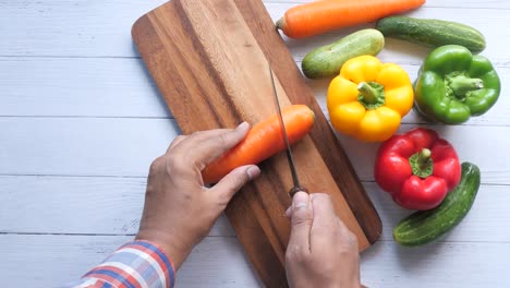 chopping carrots and other vegetables on a wooden board