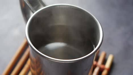 primer plano de una taza de metal con bebida caliente