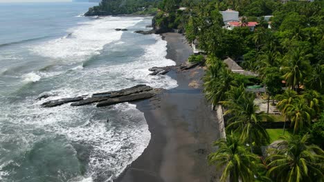 Aerial-view-moving-forward-shot,-scenic-view-of-coast-of-bitcoin-beach-on-a-bright-sunny-day-in-El-Salvador,-Mexico,-Mirador-Altos-del-Palmar-hotel-in-the-background