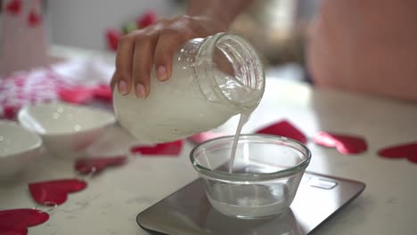 verter leche de coco en un tazón pequeño en una balanza de alimentos haciendo un pastel especial del día de san valentín pastel de chocolate vegano sin huevos a base de plantas sin lácteos