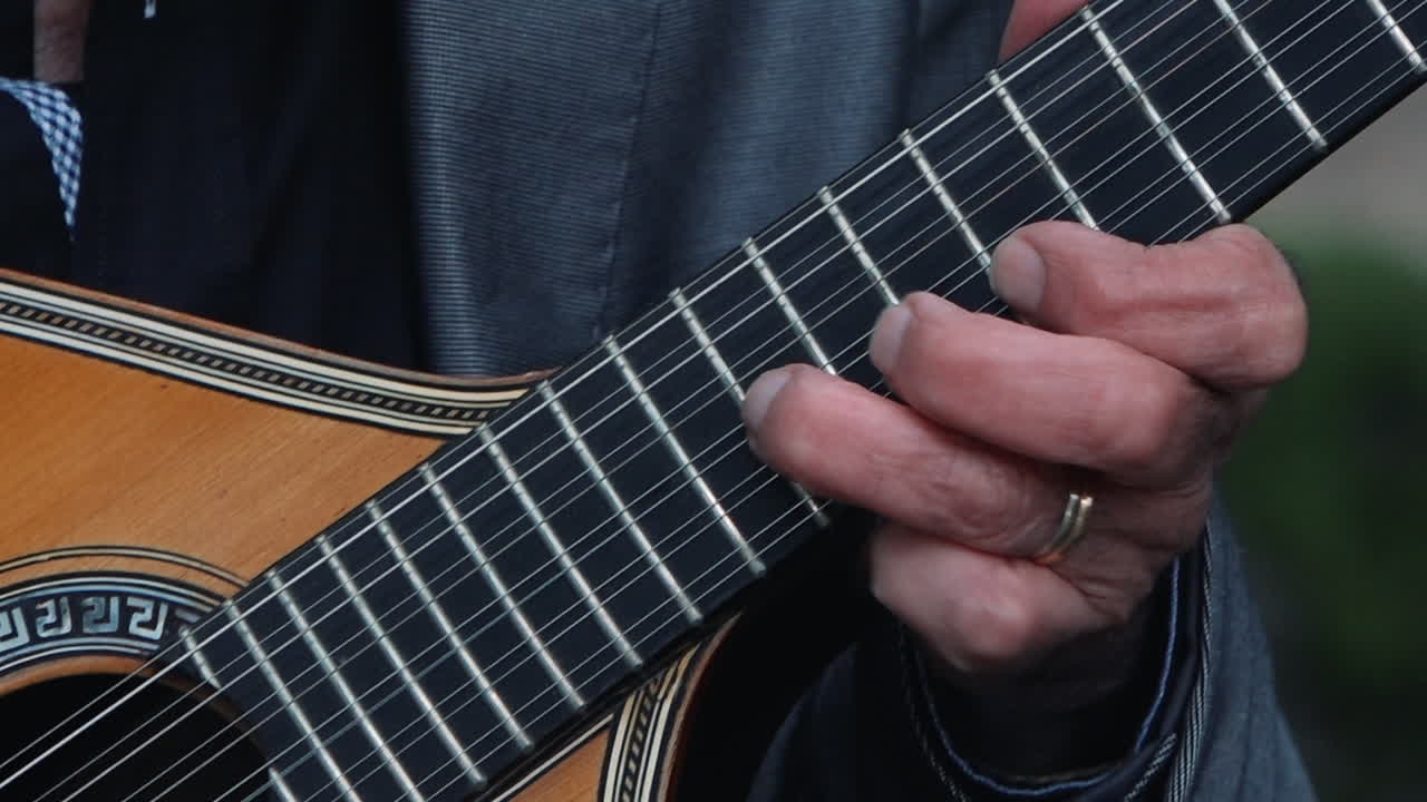 los dedos pinchando una guitarra tradicional portuguesa.