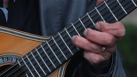 fingers plucking a traditional portuguese guitar. close up