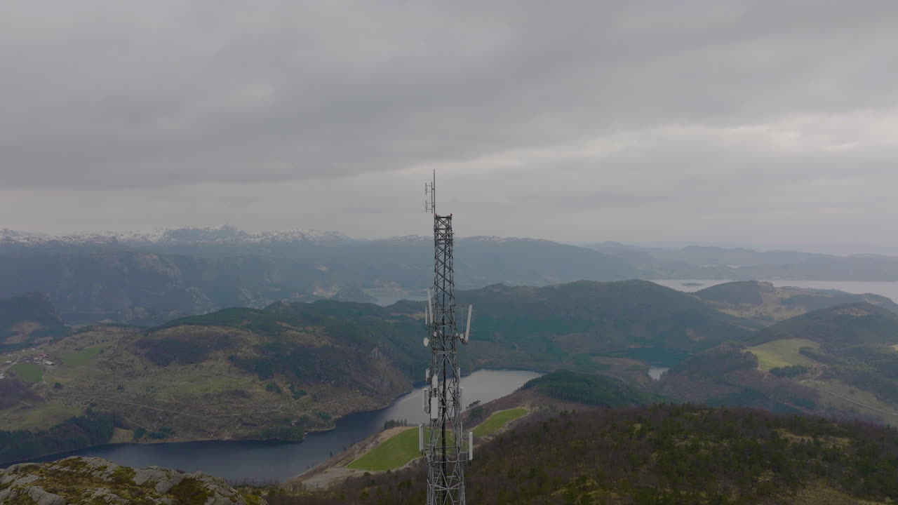 disparo de drone orbitando un mástil telefónico de 5g en un paisaje natural de montaña, noruega