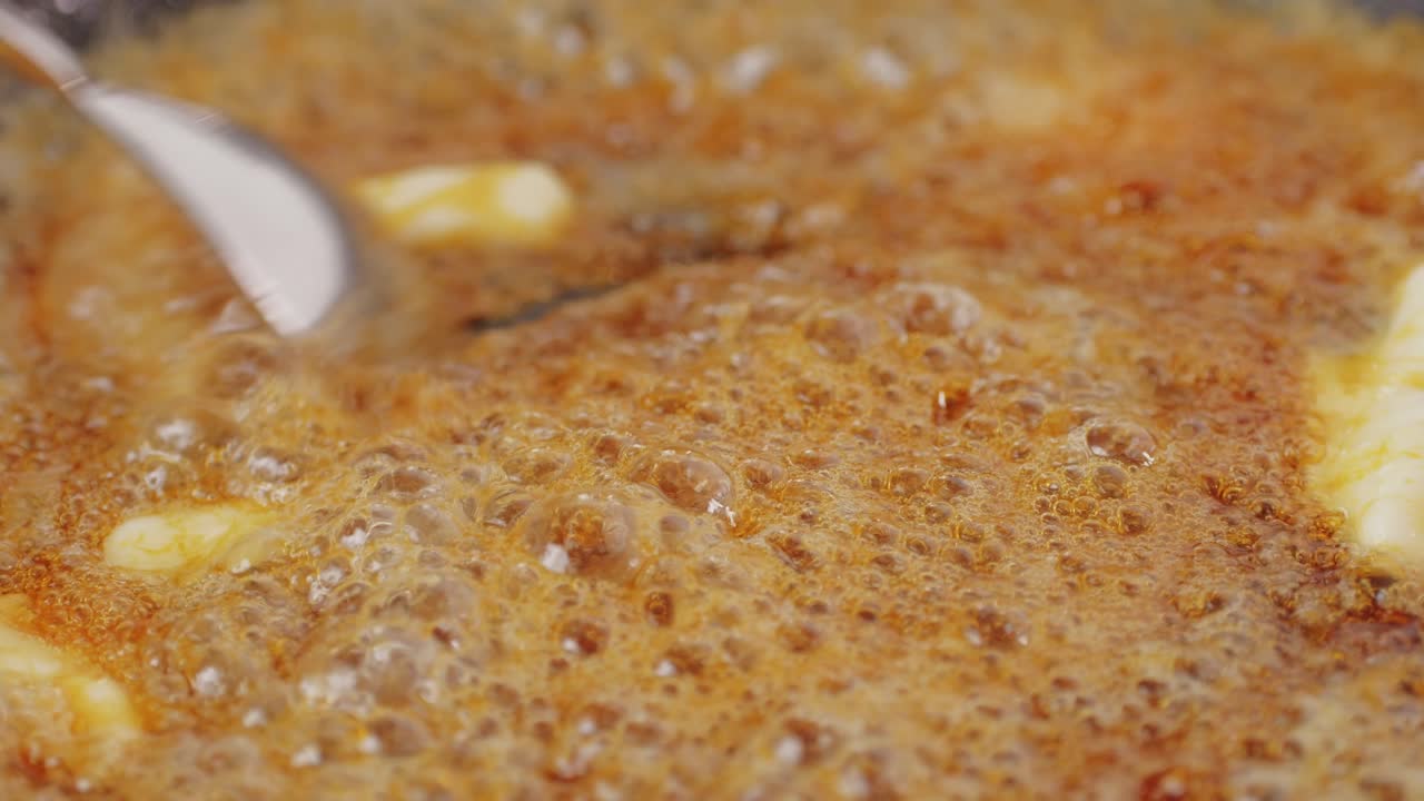 Close up of boiling sugar with bubbles turns into caramel, caramelization, chef cooking dessert in cafe, restaurant pastry food.