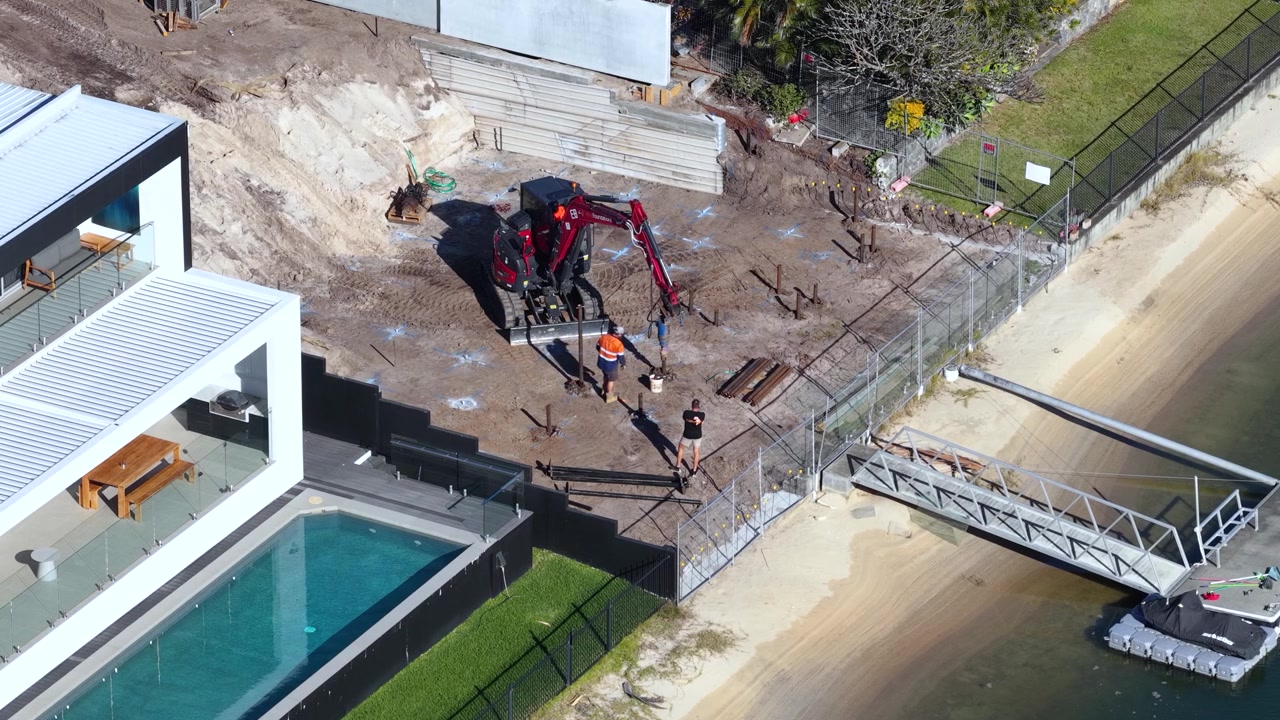 Aerial View of Construction Workers at Waterfront Residential Property