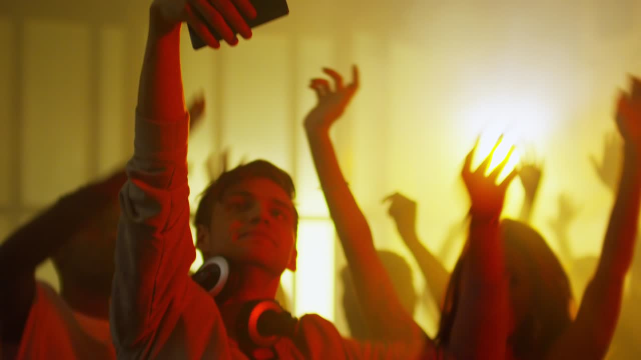 Uomo con le cuffie che scatta un selfie in discoteca