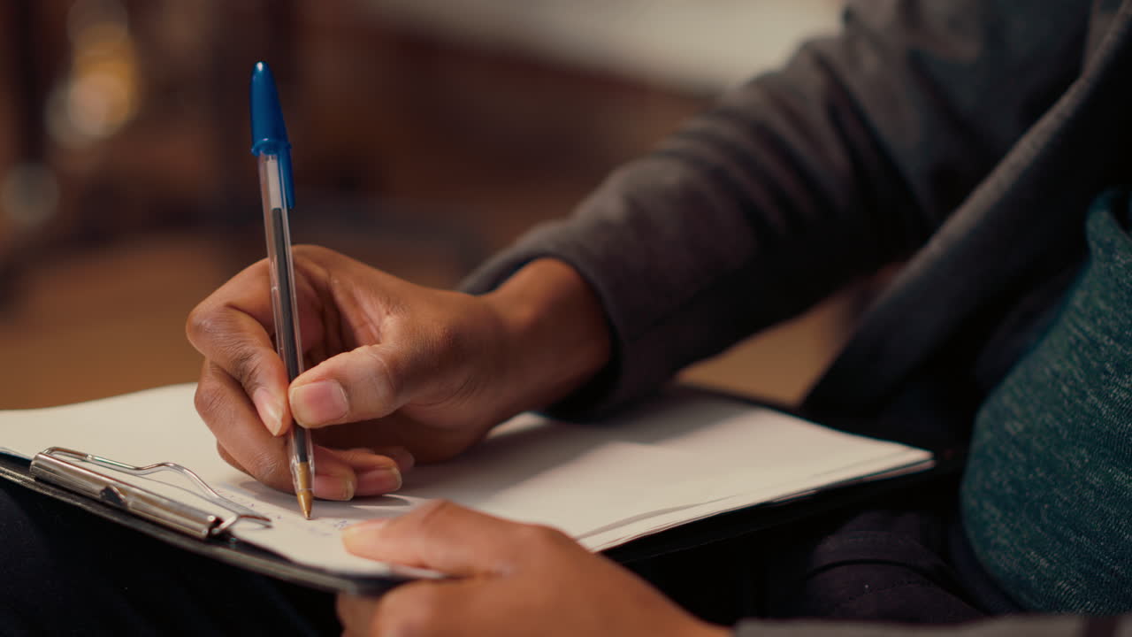Male psychologist writing notes at consultation with person